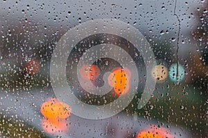 Drops on glass in rainy day. Rain outside window in the town. Texture of raindrops, wet glass. Rainy window background