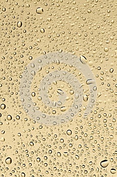 Drops on glass, sand-yellow background