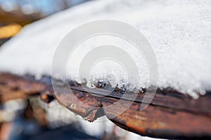 Drops of melted snow fall from the roof