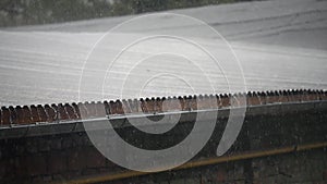 Drops of rain fall from the roof of the pavilion, raindrops flow down, close-up