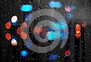 Drops of rain on glass with defocused lights. Abstract background