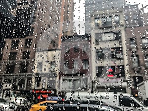 Drops of rain on a window with a city view