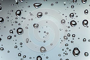 Drops of rain on the window glass on a blurred background