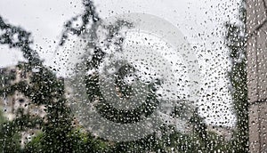 Drops of rain on the window glass on a blurred background