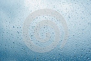 Drops of rain on the window glass Shallow DOF. Window after rain. Blue Water background with water drops