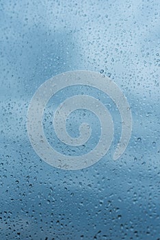 Drops of rain on the window glass Shallow DOF. Window after rain. Blue Water background with water drops