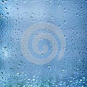 Drops of rain on the window glass. Shallow DOF. Window after rain. Blue Water background with water drops