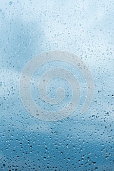 Drops of rain on the window glass Shallow DOF. Window after rain. Blue Water background with water drops