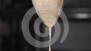 Drops of sauce pouring in slow motion. Black background. sauce or liquid drops pouring from decanter, adding to dish