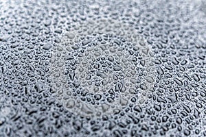 Drops of water on the black hood of the car after the rain. Abstract background