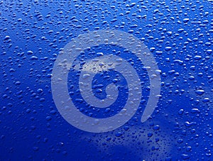 Drops of water on the blue car bonnet