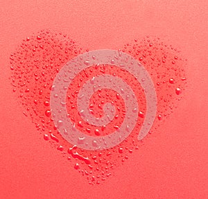 Drops of water in the form of heart on a red background