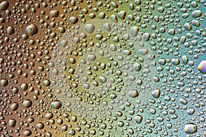 Drops of water on the glass, with the reflection of the rainbow