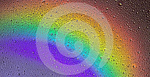 Drops of water on the glass, with the reflection of the rainbow