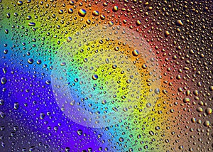 Drops of water on the glass, with the reflection of the rainbow