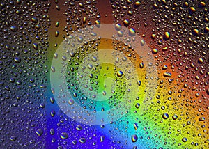 Drops of water on the glass, with the reflection of the rainbow