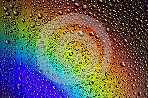 Drops of water on the glass, with the reflection of the rainbow