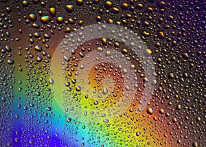 Drops of water on the glass, with the reflection of the rainbow