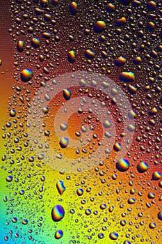 Drops of water on the glass, with the reflection of the rainbow