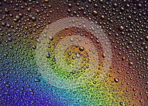 Drops of water on the glass, with the reflection of the rainbow