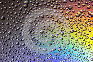 Drops of water on the glass, with the reflection of the rainbow