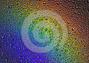 Drops of water on the glass, with the reflection of the rainbow