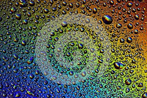 Drops of water on the glass, with the reflection of the rainbow