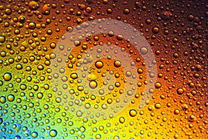 Drops of water on the glass, with the reflection of the rainbow