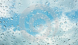 Drops of water on glass window over blue sky .