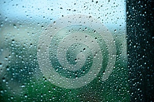 Drops of water on the glass, window. Rainy weather in the summer.