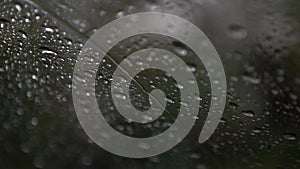 Drops of water from the rain and snow run down the glass. Car windshield from the inside in rainy weather.