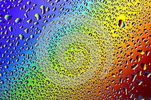 Drops of water on a rainbow background.