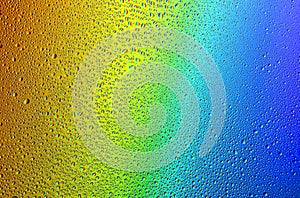 Drops of water on a rainbow background.