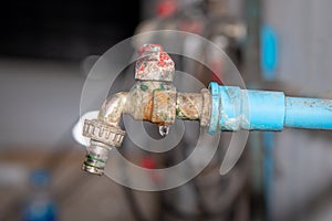 The old rusty faucet with water leaking