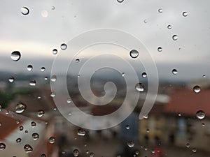 Drops of water in window glass with Barcelos city in background.