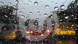 Drops of water on windshield and blur cars background.