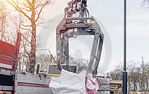 Dropside flatbed HIAB crane lorry with brick grab attachment deliver materials at construction site and offloading them