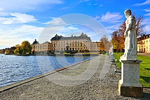 Drottningholm Palace, Swedens royal residence and statue lined lake during autumn