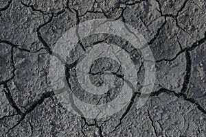 Drought. Cracks in the dry ground. Natural grey background