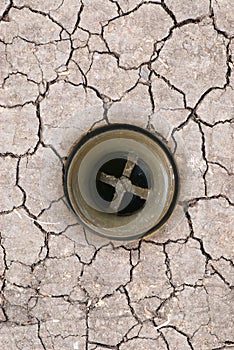 Drought on the ground. Collage sink drain on cracked dry earth.