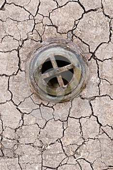 Drought on the ground. Collage sink drain on cracked dry earth.