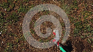 Drought or water shortage. Automatic sprinkler is spreading water over wilting dry grass in the summer backyard. Arid