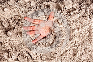 Drowning hand in white sand