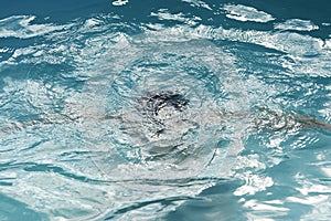 Drowning kid into swimming pool water, close-up