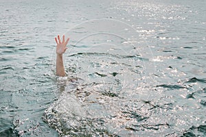 Drowning man, asking for help. Sticking hand out of water