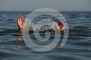 Drowning man reaching for help in sea