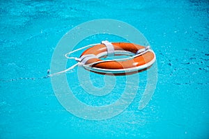 Drowning in water catch lifebuoy. Safety and urgent help. Resque needed. Life buoy floating in pool. photo