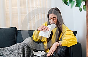 Drowsy young adult woman, preparing to sneeze in tissue