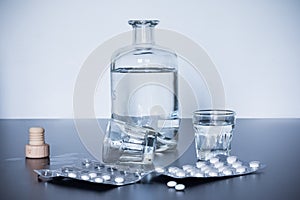 Drug abuse: Close up of pills and alcohol on a grey table