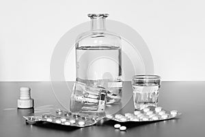 Drug abuse: Close up of pills and alcohol on a grey table